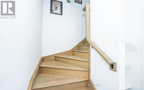 Niagara Falls (Downtown) townhouse for rent - A wooden staircase with a metal handrail.