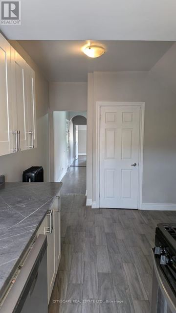 Hamilton (Blakeley) apartment for rent - A kitchen with white cabinets and a white door.
