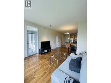 Vancouver apartment for rent - A living room with a grey couch and a wooden floor.