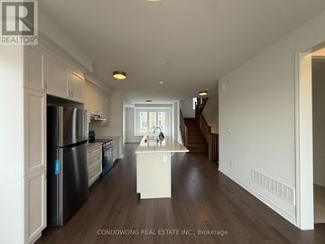 Markham townhouse for rent - A kitchen with white cabinets and a stainless steel refrigerator.