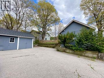 Richmond Hill (Mill Pond) apartment for rent - A gravel driveway leads to a garage with a blue house in the background.