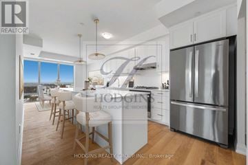 Mississauga (Clarkson) condo for rent - A modern kitchen with a stainless steel refrigerator and wooden flooring.