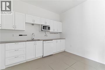 Cambridge apartment for rent - A kitchen with white cabinets and a microwave above the oven.