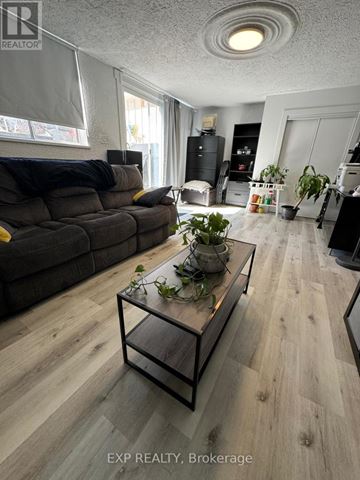Mississauga (Streetsville) apartment for rent - A living room with a grey couch and a glass coffee table.