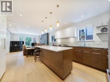 Vancouver apartment for rent - A modern kitchen with a large island and pendant lights.