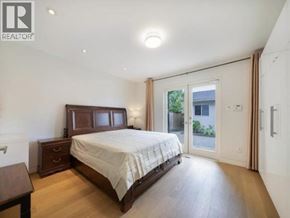 Vancouver apartment for rent - A bedroom with a large bed, wooden furniture, and a sliding glass door.