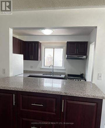 Mississauga (Erindale) apartment for rent - A kitchen with brown cabinets and granite countertops.