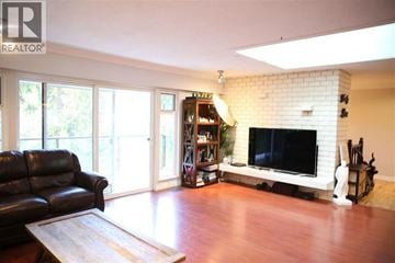 West Vancouver apartment for rent - A living room with a black leather couch and a fireplace.