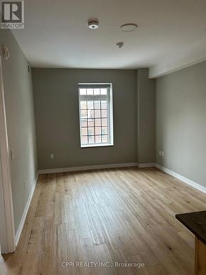 Oshawa (Central) condo for rent - A room with a window and wooden flooring.
