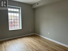 Oshawa (Central) condo for rent - A room with a window and wooden flooring.