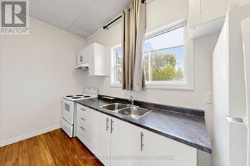 Halton Hills (Georgetown) multi-family for rent - A kitchen with white cabinets and a black countertop.