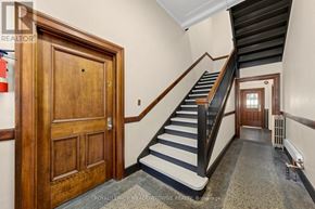 Halton Hills (Georgetown) multi-family for rent - A staircase with a wooden banister and a black and white striped carpet.