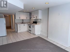 Toronto (North Riverdale) townhouse for rent - A kitchen with white appliances and cabinets is on the market with Chestnut Park Real Estate Limited.