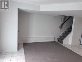 Toronto (North Riverdale) townhouse for rent - A room with a staircase and a carpeted floor.
