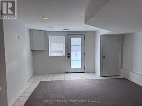 Toronto (North Riverdale) townhouse for rent - A room with a grey carpet and white walls.