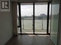 Toronto (Bay Street Corridor) condo for rent - A glass door with a view of a lake and trees outside.