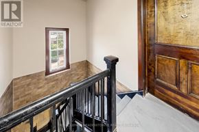 Halton Hills (Georgetown) apartment for rent - A room with a wooden door and a window with a view of trees and houses outside.