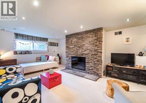 North Vancouver apartment for rent - A living room with a stone fireplace and a television.