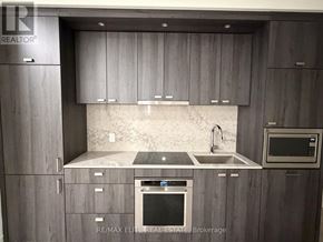 Toronto (Dovercourt-Wallace Emerson-Junction) condo for rent - A modern kitchen with grey cabinets and stainless steel appliances.