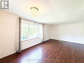 Toronto (Dorset Park) apartment for rent - A room with wooden floors and a window with curtains.