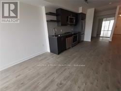 Toronto (Church-Yonge Corridor) condo for rent - A spacious kitchen with dark wood cabinets and a white wall.