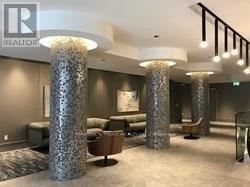 Toronto (Church-Yonge Corridor) condo for rent - A spacious waiting area with a grey carpet and a row of tall, patterned columns.