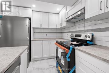 Ottawa apartment for rent - A kitchen with white cabinets and a stainless steel refrigerator.
