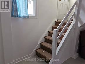 Toronto (Tam O'shanter-Sullivan) apartment for rent - A staircase with a white railing and brown steps.