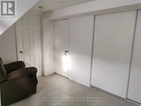 Toronto (Tam O'shanter-Sullivan) apartment for rent - A room with white walls and a brown couch.