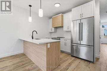 Central Elgin (Port Stanley) house for rent - A kitchen with a white counter top and a stainless steel refrigerator.