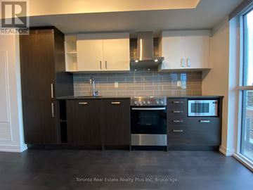 Toronto (Mount Pleasant West) condo for rent - A modern kitchen with dark wood cabinets and stainless steel appliances.