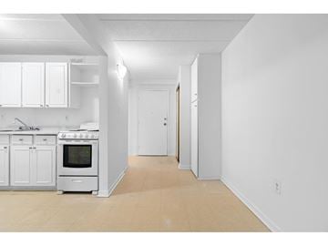 Gatineau (Aylmer) apartment for rent - A white kitchen with a stove top oven and a white fridge.