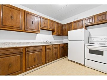 Gatineau (Aylmer) apartment for rent - A kitchen with white appliances and wooden cabinets.