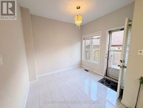 Oakville (Ro River Oaks) townhouse for rent - A room with a sliding glass door and a chandelier hanging from the ceiling.