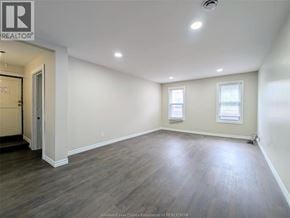 Windsor duplex for rent - A spacious room with wooden flooring and white walls.