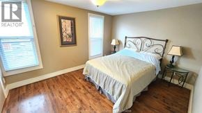 Windsor duplex for rent - A bedroom with a bed, nightstand, and lamp.