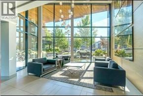 Vancouver apartment for rent - A large glass window with a view of trees and a car outside.