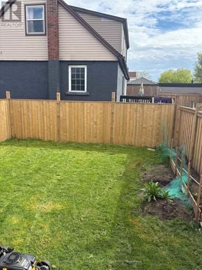 Hamilton (Hamilton Beach) apartment for rent - A backyard with a wooden fence and a small tree.