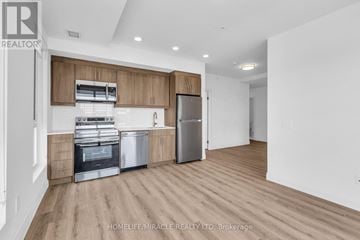 Kitchener condo for rent - A kitchen with wooden cabinets and stainless steel appliances.