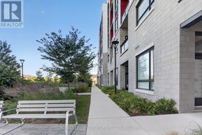 Oakville (Go Glenorchy) condo for rent - A white bench is on a concrete walkway in front of a building.