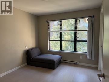 Vancouver townhouse for rent - A living room with a black sofa and a window with blinds.