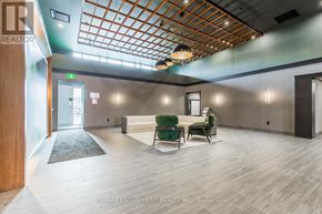 Hamilton (Waterdown) condo for rent - A spacious room with a wooden ceiling and a green chair.
