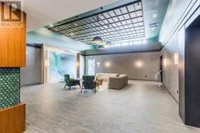 Hamilton (Waterdown) condo for rent - A modern office space with a skylight, wood floors, and a green and white patterned pillar.