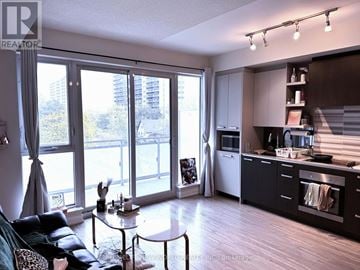 Toronto (High Park North) condo for rent - A modern kitchen with a view of the city outside the large windows.