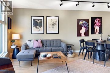 Vancouver apartment for rent - A living room with a grey sofa, a coffee table, and a dining table with chairs.