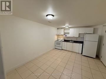 Toronto (West Hill) multi-family for rent - A kitchen area with white cabinets and appliances.