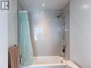 Mississauga (City Centre) condo for rent - A bathroom with a shower curtain and a towel hanging on the wall.