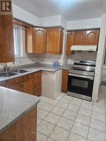 Toronto (Bendale) apartment for rent - A kitchen with wooden cabinets and a marble countertop.