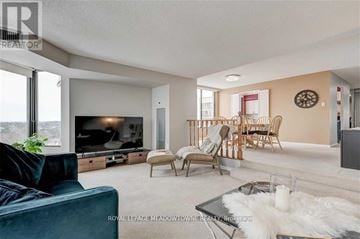 Mississauga (Meadowvale) condo for rent - A living room with a dark blue sofa and a glass coffee table.