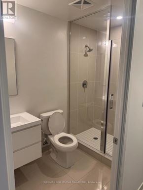 Markham (Unionville) condo for rent - A white toilet in a bathroom with a glass shower door.